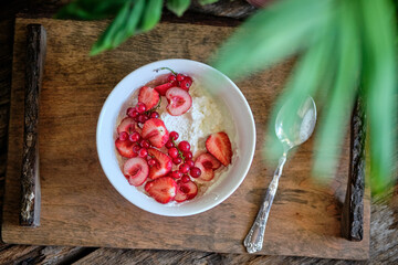 Bowl with cottage cheese, cream, strawberries, red currants and cherries