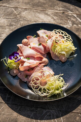 A plate of thinly sliced cooked ham, perfect for sandwiches, appetizers, or traditional meals. Fresh and savory, ideal for culinary presentations.