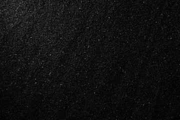 Top view black sand texture background. Dark Sand macro photography