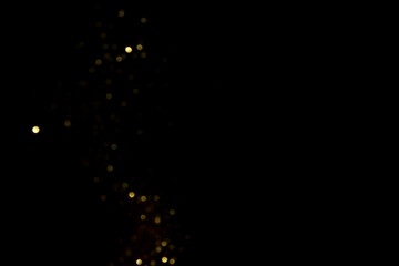 Golden blurred bokeh lights on black background. Glitter sparkle stars for celebrate. Overlay for your design