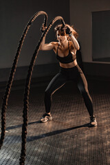 Engaging in a Dynamic Workout with Battle Ropes set in a Contemporary Gym Environment for an energized fitness experience. Ideal for those dedicating themselves to achieving optimal health