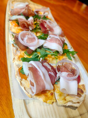 Grilled pizza with prosciutto ham, mozzarella cheese and green salad