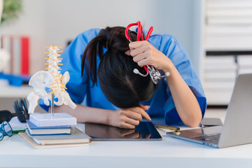 Exhausted Doctor: A female doctor rests her head on her desk, overwhelmed by the demands of her...