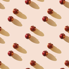 Red apples on light beige pastel background with long shadow. Seamless pattern
