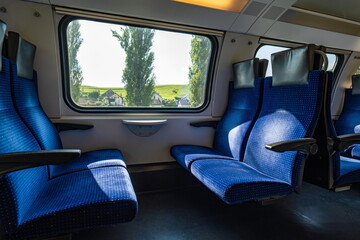 Empty seats in a public passenger train in Switzerland, Europe. Wide angle, natural window light, no people