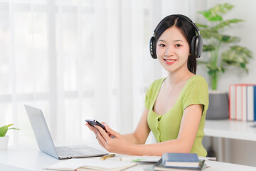 Smiling Woman Working From Home with Headphones and Laptop 