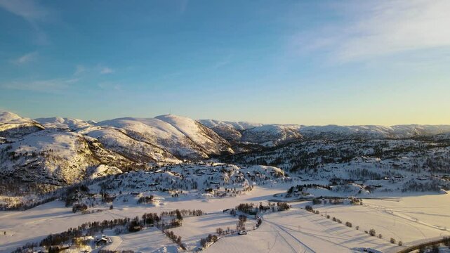 Drone shot over Sirdal Agder Norway at winter with blue skies and low sun