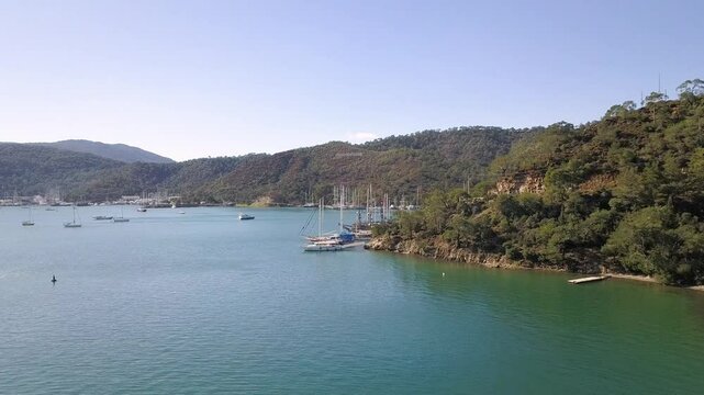 Drone view of a peaceful seashore with docked sailing boats in Marmaris Turkey 