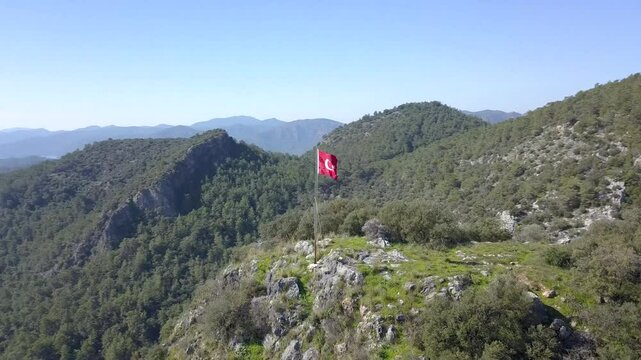 Breathtaking 360-drone view of the coastal town Gocek, Fethiye Turkey as seen from a hilltop with the Turkish flag