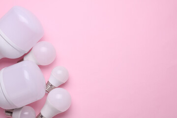 Different led light bulbs on a pink background. Copy space