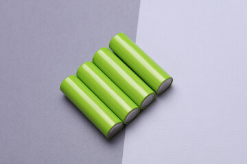 Green AA batteries on a gray background