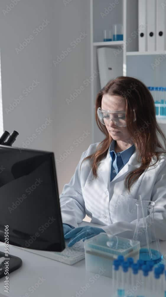 Poster in the laboratory, a female scientist is diligently using a computer for her innovative research and