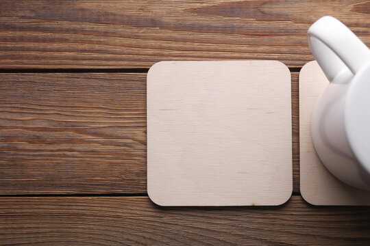Wooden square drink coasters and cup on the table