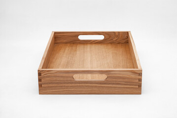 Solid ash wood tray with dovetail joints and cutout handles on the sides for easy carrying on white background