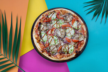 Vegetarian Pizza with Eggplant and Zucchini on a Colorful Tropical Background