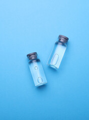 Medical glass vials with liquid on a blue background