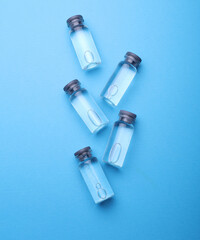 Medical glass vials with liquid on a blue background