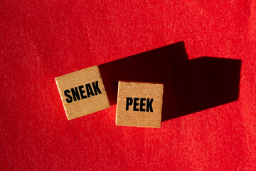 Sneak peek message written on wooden cubes with red background. Conceptual sneak peek symbol. Copy...