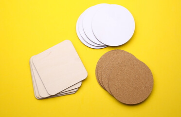 Cork, white, wooden coasters for drinks on a yellow background