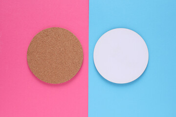 Cork and white coasters for drinks on blue pink background