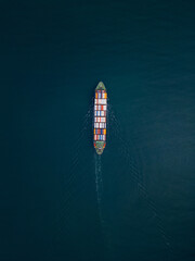 A container ship sails across the calm blue waters