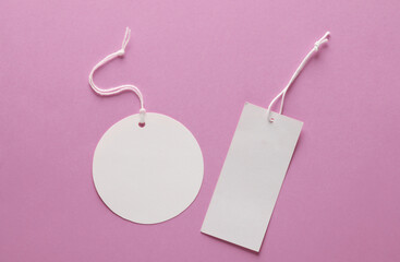 Empty rectangular and round white price tags with string on pink background. Template for design