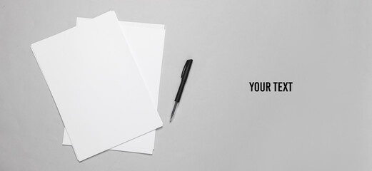 White blank sheets of a4 paper size or documents mockup with pen on a gray background. Template for...