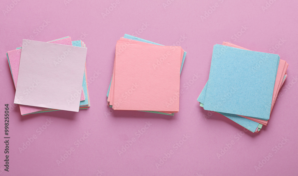 Poster colored square memo sheets of papers on pink background. top view