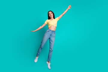 Obraz premium Full size photo of pretty young woman jump arm hold empty space wear top isolated on teal color background
