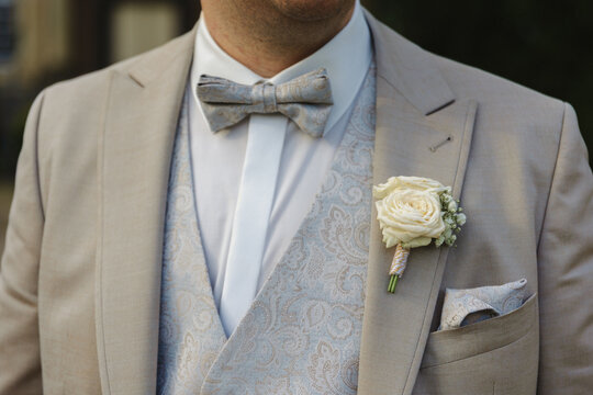 Grooms elegant, grey, suit with bow and white rose
