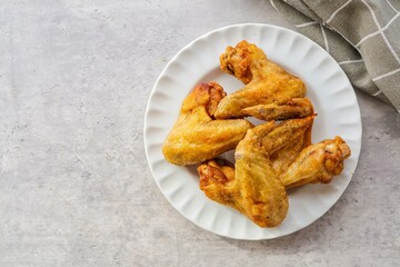 Home made Fried chicken wings  in a white plate on cement  background top view  table