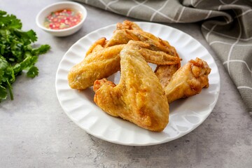 Home made Fried chicken wings  in a white plate on cement  background 