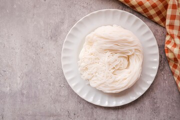 Thai rice noodle in white plate on grey background , top view food table , thai called Khanom Jeen