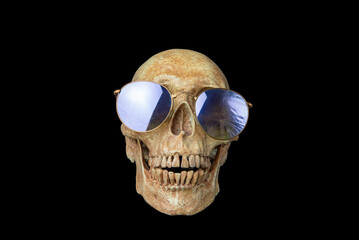 Human skull wears sunglasses on black background