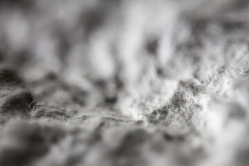 Extreme close up of old gray handmade paper clay with a structure and rough texture. Paper recycling. Selective focus, shallow depth of field.