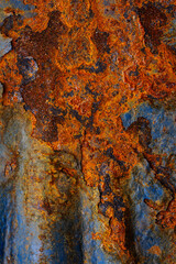 Rusty metal surface with shabby background paint. Blue cracked paint texture on an iron sheet. Fragment of an old metal door, Metal corrosion.