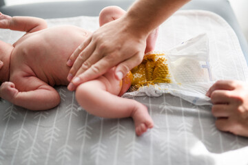 Close up on hand man changing diapers dirty shit on her newborn baby
