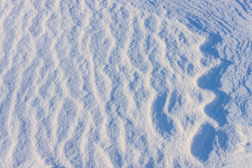 Close-up of a sandy, rippled texture on a snow surface.