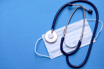 On the table lay a stethoscope and a protective respirator mask