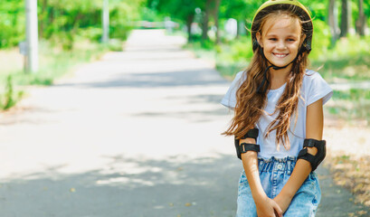 Portrait of a smiling child girl skateboarder wearing helmet, elbow and knee support for body safety protect. Copy space