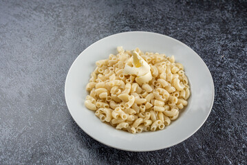 Pasta on a white plate on a gray background