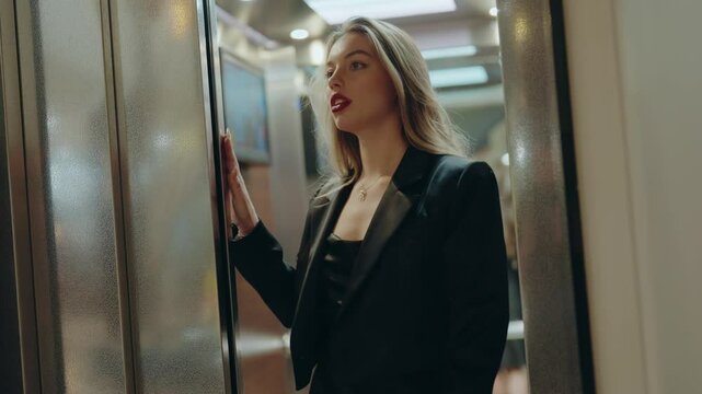 Confident woman in a black blazer stepping out of the elevator. Office setting with professional atmosphere. Suitable for concepts of business, career, and professional lifestyle. Stylish Woman