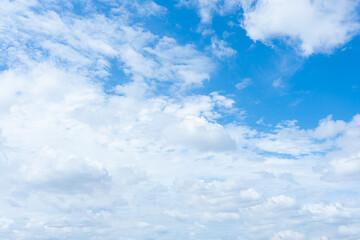 A clear blue sky filled with fluffy white clouds on a sunny day