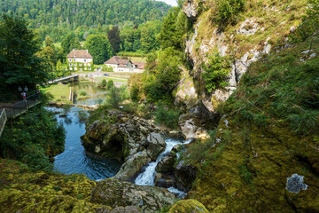 Fototapeta premium Hiking trail above Pertes de l'Ain waterfalls with view on Bourg-de-Sirod, Jura, France