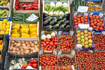 Colorful variety of tomatoes and other vegetables seen at a market in Italy