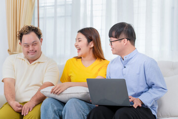 A group of friends using laptop doing a video call in living room, Man and woman sitting on sofa...