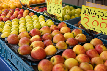 Different types of apples at a market stall. Ripe stone fruits. Haagse Market in The Hague, Netherlands.