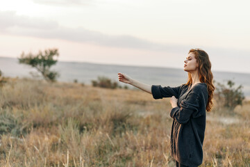 empowered woman pointing towards the horizon in vast open field