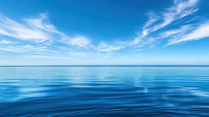 Obraz premium Picture a clear, bright blue sky with a few wispy clouds, stretching over a tranquil sea.