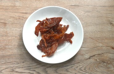 salty and sweet dry fried slice pork meat fermenting in sesame oil on plate